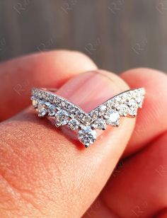 a hand holding a diamond ring in it's left hand, with the middle finger pointing