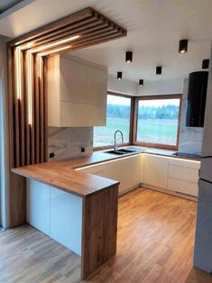 an empty kitchen with wood flooring and white cabinetry on the walls is shown