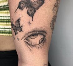 a close up of a person's arm with tattoos on it and butterflies flying around