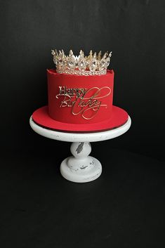 a red and gold birthday cake with a crown on top