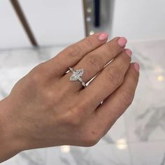 a woman's hand with a diamond ring on it