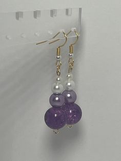 Add a touch of elegance to your jewelry collection with these stunning beaded earrings featuring a purple crystal like bead and a white pearl like bead. The combination of the deep purple hue and the classic white creates a timeless look that can be dressed up or down. The dainty size of the white pearl adds a delicate touch to the overall design, making these earrings a versatile accessory for any outfit. Handcrafted with care, these earrings are sure to make a statement wherever you go. Elegant Lavender Beaded Drop Earrings, Elegant Lavender Beaded Earrings With Dangling Beads, Lavender Earrings With Dangling Beads For Gifts, Purple Faceted Beaded Round Earrings, Purple Faceted Beaded Earrings, Elegant Purple Beaded Earrings With Faceted Beads, Elegant Purple Earrings With Dangling Beads, Elegant Purple Crystal Earrings With Dangling Beads, Purple Dangling Beads Crystal Drop Earrings