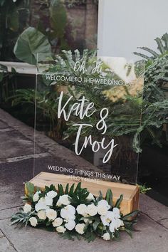 a sign that says welcome to the newly married couple and flowers in front of it