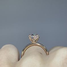 a woman's hand holding an engagement ring with a large diamond on the side