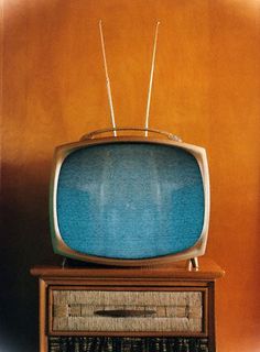 an old fashioned television sitting on top of a wooden dresser