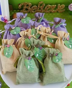 several small bags with tags on them sitting on a plate in front of a sign