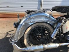 an old motorcycle parked in front of a garage