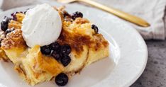 a white plate topped with blueberry cobbler and ice cream on top of it