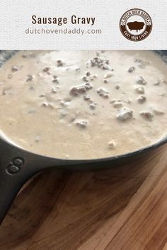 sausage gravy in a skillet on top of a wooden cutting board with the words sausage gravy above it