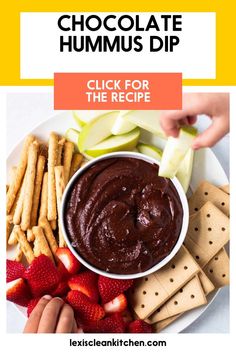 a plate with crackers, apples and strawberries on it next to a bowl of dip