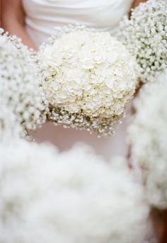 the bride is holding her bouquet of white flowers