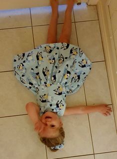 a little boy laying on the floor in front of a bathroom door with his feet up