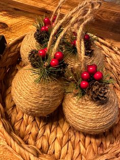 some red berries and pine cones are sitting in a basket with twine on it