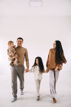 a man, woman and child are walking in an empty room with their arms around each other