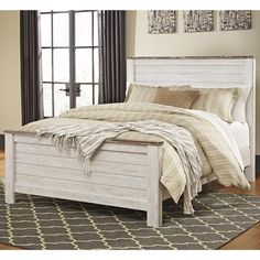 a white bed sitting on top of a wooden floor