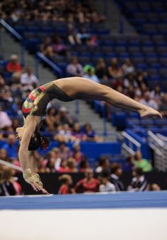 a woman on the balance beam in front of an audience