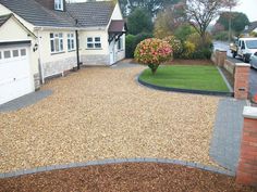 a driveway with gravel and grass in front of it