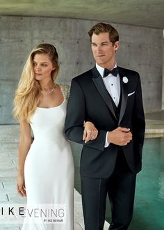 a man in a tuxedo standing next to a beautiful woman