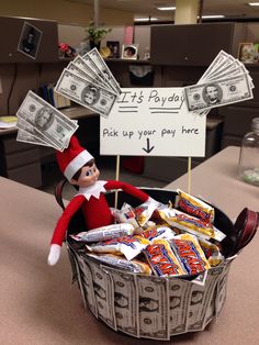 an elf is sitting in a basket full of money