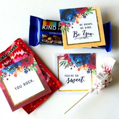 three candy bars and some cards on a table