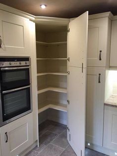 an empty kitchen with white cupboards and gray flooring is pictured in this image