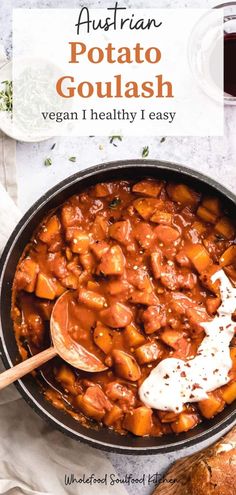 a pot filled with meat and vegetables on top of a white table next to bread