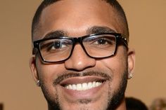 a close up of a person wearing glasses with a smile on his face and beard