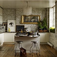 a kitchen with two stools in front of the counter and a painting on the wall