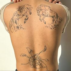 the back of a woman's body with tattoos on it