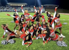 the cheerleaders are posing for a group photo on the football field at night