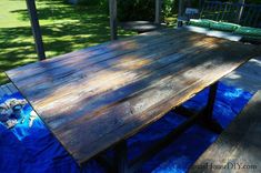 a wooden table sitting on top of a blue tarp