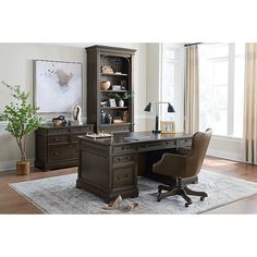 an office desk with two chairs and a bookcase