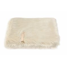 a white fur pillow with a leather tag on the front and back of it's cover