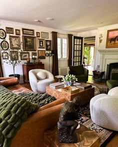 a living room filled with lots of furniture and pictures on the wall above it's fireplace