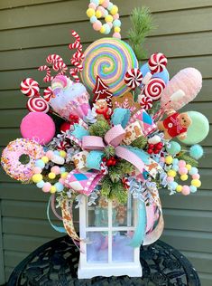 an arrangement of candy, candies and lollipops in a vase