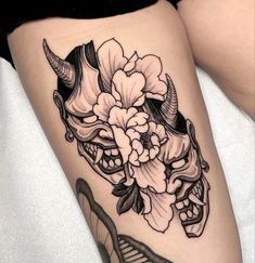 a woman's thigh with a skull and flowers on it