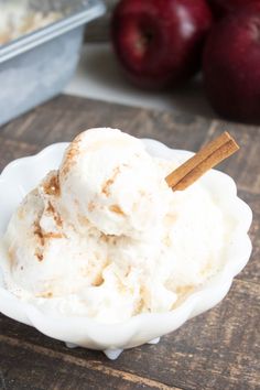 two scoops of ice cream in a white bowl with cinnamon stick sticking out of it