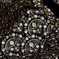 a close up view of a black and pink paisley print fabric with white flowers on it