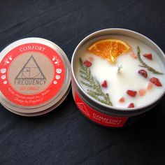 an orange slice is in a bowl next to a tin of yogurt that has fruit on it