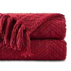 a red blanket with fringes on the bottom and one end folded up to show it's texture