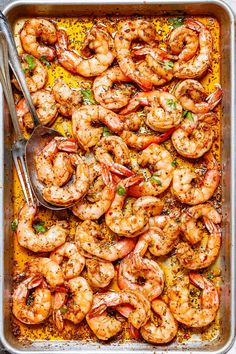 a pan filled with cooked shrimp and garnished with parsley on the side