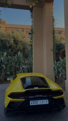 a yellow sports car parked in front of a building