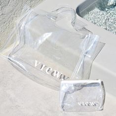 Our Clear Tote Beach Bag is a stylish and spacious companion for beach outings, picnics, or shopping days. Paired with our perfect beauty essential Clear Cosmetic Bag, this set is a must-have! Clear Tote Beach Bag: 0.6mm Clear PVC. Length: 34cm. Height: 45.5cm. Width: 13.5cm. The Clear Cosmetic Bag: 0.6mm Clear PVC. Stainless Steel Zipper. Length: 15cm. Height: 20cm. Width: 5cm Summer Large Capacity Clear Shoulder Bag, Large Capacity Clear Shoulder Bag For Summer, Large Capacity Clear Bags For Beach, Casual Clear Beach Bag, Clear Bags For Daily Summer Use, Trendy Clear Shoulder Bag For Beach, Trendy Clear Shoulder Bag For The Beach, Clear Shoulder Bag For Beach, Clear Rectangular Shoulder Bag For Summer