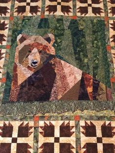 a bear is sitting in the middle of a quilt