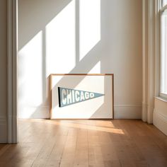 a chicago sign sitting on top of a hard wood floor next to a white wall