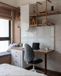 a bedroom with a bed, desk and shelves above it in front of a window