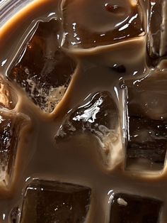 some ice cubes are melting in brown liquid