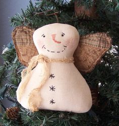 an angel ornament hanging from a christmas tree