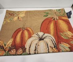 a place mat with pumpkins and leaves on it