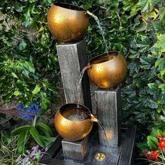 an outdoor fountain with three bowls on it and water spouting from the top